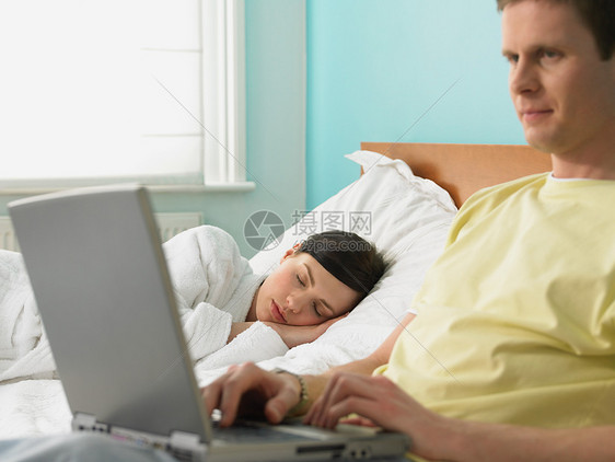 躺在床上的年轻夫妇图片