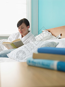 在床上看书的年轻女子图片
