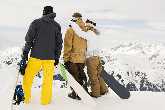 三个人拿着滑雪板的背影图片