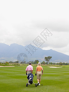 一对夫妇在高尔夫球场上散步图片
