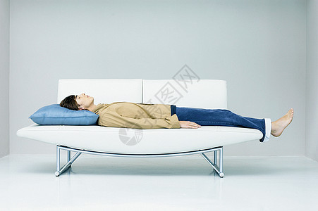躺在现代沙发上的男人图片