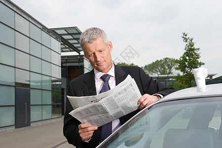 商人在车旁看报纸图片