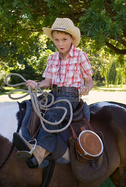 骑着马牵着套索的男孩图片