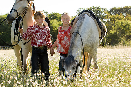 女孩和马牵着马的男孩和女孩背景