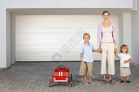 母亲和孩子们站在车库外图片