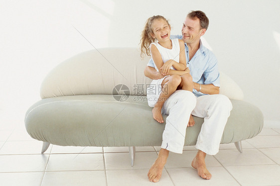 坐在沙发上的父女图片