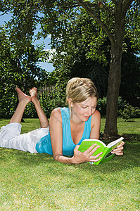 趴在草地上看书的女人图片