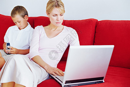 母亲和儿子在玩笔记本电脑图片