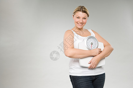 拿着体重秤的女人图片