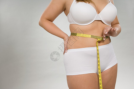 测量腰围的女人图片
