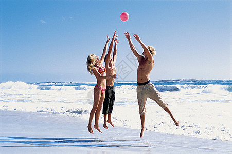 海滩上玩排球的年轻人图片