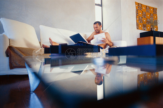 在客厅用笔记本电脑学习的男人图片