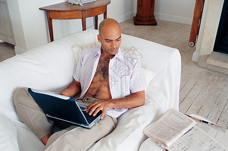 沙发上用笔记本电脑的男人图片