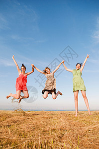 三个女孩跳起来，双手高举图片