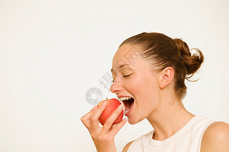 美女张嘴吃红苹果的女孩背景