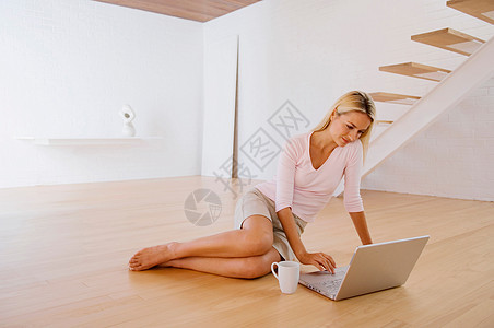 女人在地板上用笔记本电脑图片