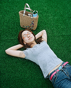 躺在人造草坪上的女子图片