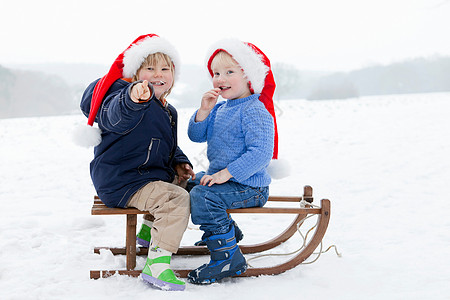 两个男孩在雪橇图片