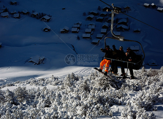 从滑雪缆车上挥手的滑雪者图片