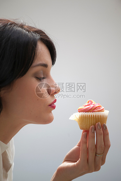 女人吃纸杯蛋糕图片