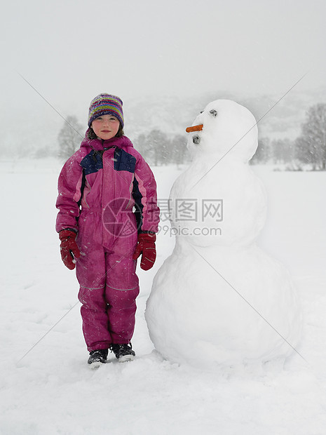 站在雪人旁边的女孩图片