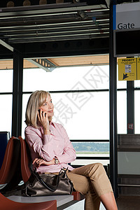 在机场候机厅打电话的中年妇女图片