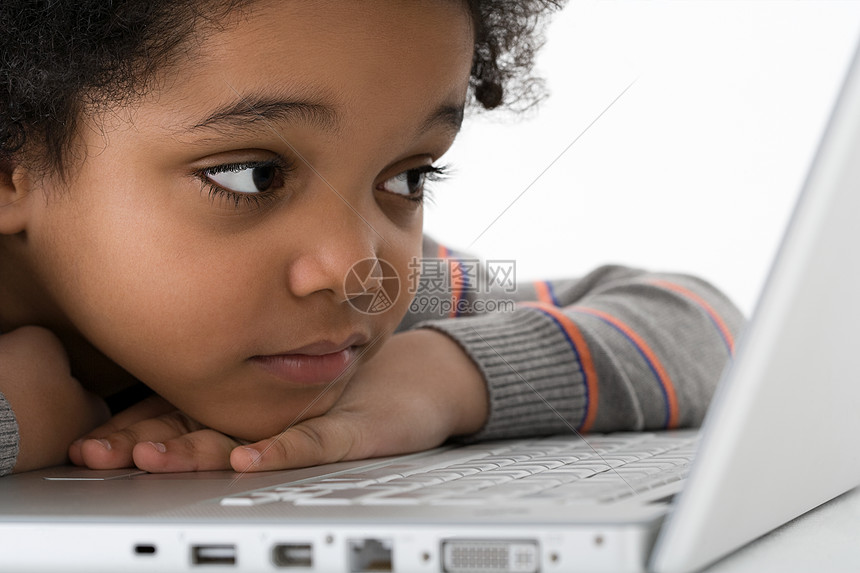 男孩靠在笔记本电脑上图片