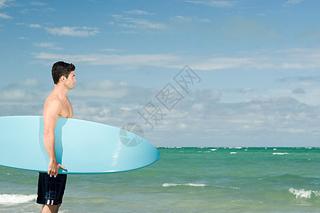 拿着冲浪板的年轻人图片