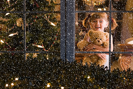 小女孩在窗户边上看雪图片