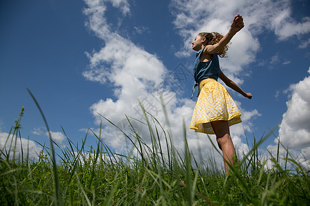 女孩站在田野上伸出双臂图片