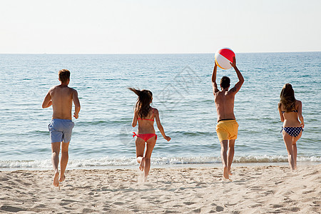 四个人在海滩上玩沙滩球图片