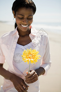 在海滩上拿花的女人图片