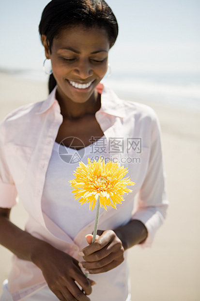 在海滩上拿花的女人图片