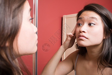 在镜子里看镜子的年轻女人图片