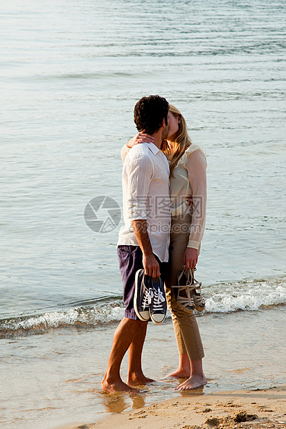 年轻夫妇在海滩上接吻图片