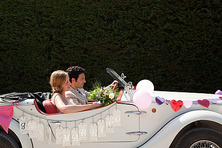 新婚夫妇乘老爷车去度蜜月背景图片