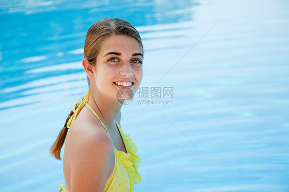 游泳池边穿黄色比基尼的年轻女子图片