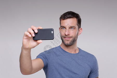 中年男子使用智能手机拍照图片