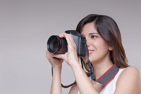 年轻女子用数码单反相机拍照图片