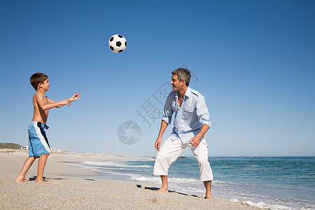 父子俩在海边踢足球图片