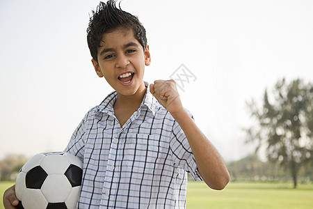 一个男孩拿着一个足球的肖像图片