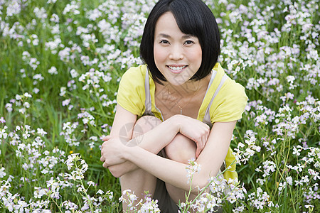 坐在花丛里的年轻女子图片