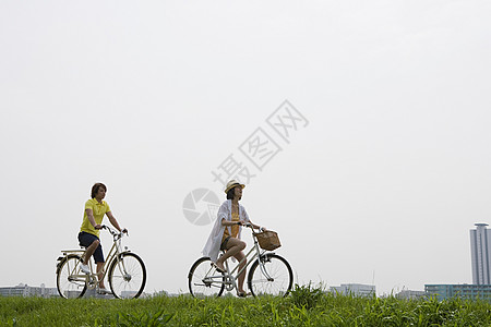 东京女子图鉴年轻夫妇骑自行车背景