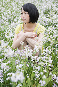 坐在花丛里的年轻女子图片