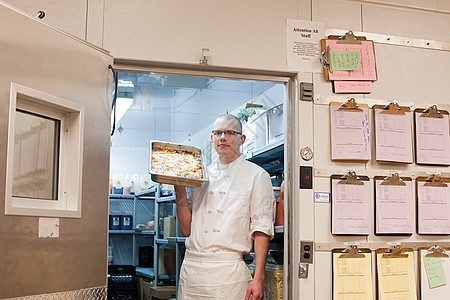 商业厨房步入式冷冻室的男厨师图片