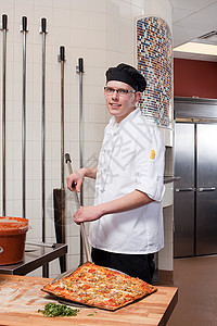 男厨师在商业厨房做披萨背景图片