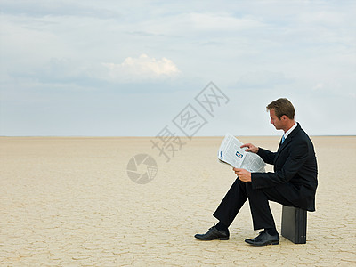 商人在沙漠里读报纸图片