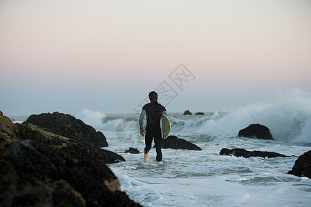冲浪运动员站在海里图片