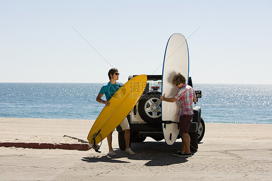 两个年轻人与带冲浪板图片