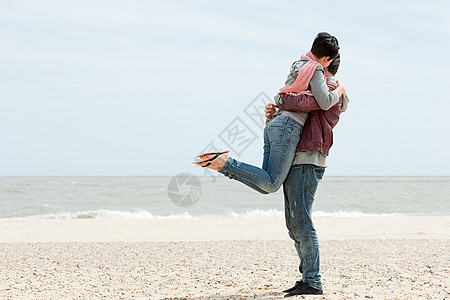 海边父子海边的男人举起女友背景